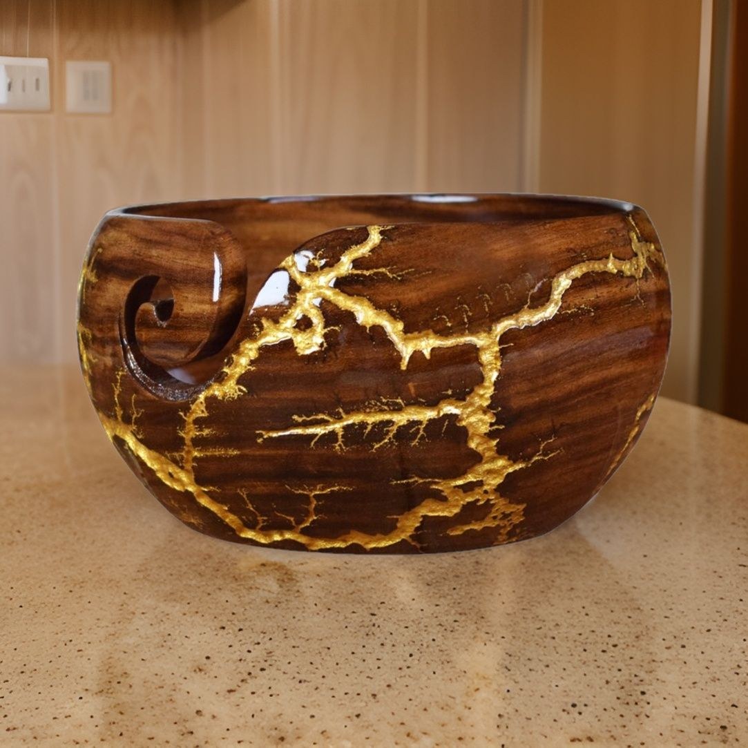 Wooden yarn bowl with gold-colored decorative lines and a yarn guide